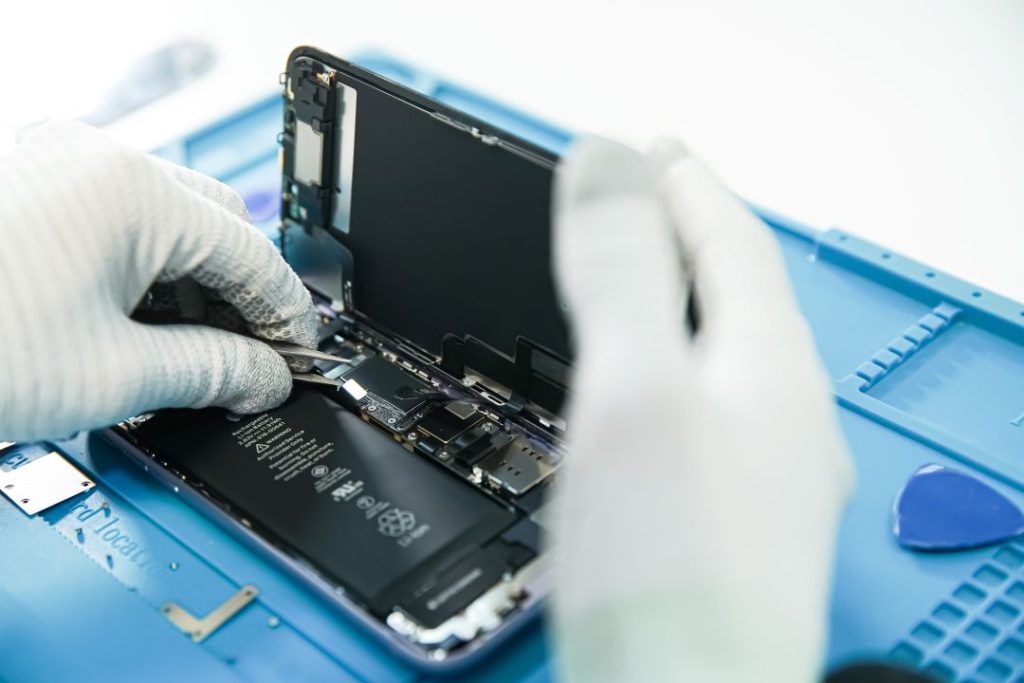 Technicien réparant avec précision l’intérieur d’un smartphone